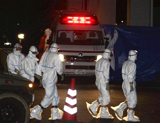 Medical workers in protective gear gather around an ambulance which arrived at a hospital in Fukushima City, Fukushima Prefecture, Japan, carrying two workers from the tsunami-damaged Fukushima Dai-ichi nuclear power plant after they stepped into contaminated water while laying electrical cables in one unit Thursday, March 24, 2011. (AP Photo/Yomiuri Shimbun, Jun Yasukawa) JAPAN OUT, MANDATORY CREDIT (AP)