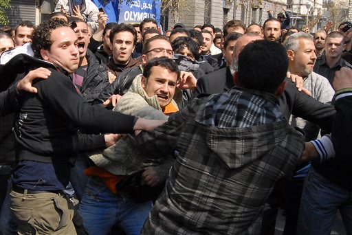 Anti-Syrian government protesters, left, and pro-government, right, clash after Friday prayers in Damascus, Syria, Friday, March 25, 2011. Thousands of Syrians took to the streets Friday demanding reforms and mourning dozens of protesters who were killed during a violent, week long crackdown that has brought extraordinary pressure on the country's autocratic regime, activists and witnesses said. (AP Photo/Muzaffar Salman) (AP)