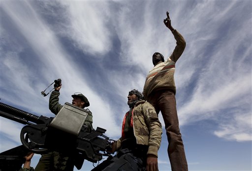 Anti-Libyan Leader Moammar Gadhafi rebels, stand on their vehicle shout slogans against Gadhafi at a desert road between Agela and Ras Lanouf towns, eastern Libya, on Saturday March 12, 2011. An emergency European Union summit on Libya brought a no-fly zone no closer, but leaders embraced a new Libyan opposition group as a viable partner after cutting all contact with strongman Moammar Gadhafi. (AP Photo/Hussein Malla) (AP)