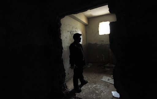 In this photo taken Tuesday, March 8, 2011, Libyan businessman Fadlallah Haroun, 45, who spent seven years in Moammar Gadhafi's prisons without being charged, stands in a cell at a stormed security base in the city of Benghazi, the Katiba building, where he spent 14 days before being transferred to Abu Selim prison in Tripoli, Libya. Now that eastern Libya has ripped itself free from Gadhafi's grip, residents there finally feel safe to talk about what life was like under the regime. The stories they tell are stamped with the terror, paranoia and sinking sense of desperation instilled in the people by Gadhafi since he took power in a 1969 coup. (AP Photo/Nasser Nasser) (AP)