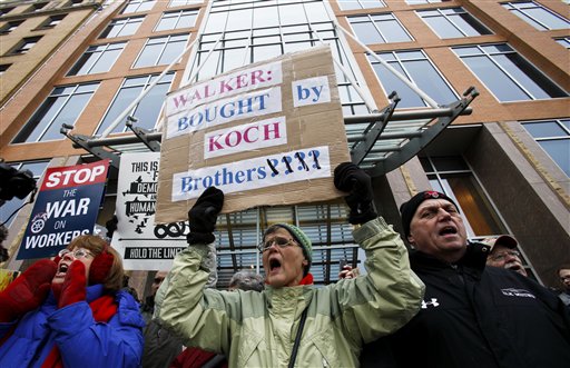 Jane Pederson, center, of Menomonie, Wis., protests in front of the offices of Koch Industries in Madison, Wis., Thursday, Feb. 24, 2011. Opponents to the governor's budget are in their tenth day of protests. (AP Photo/Andy Manis) (AP)