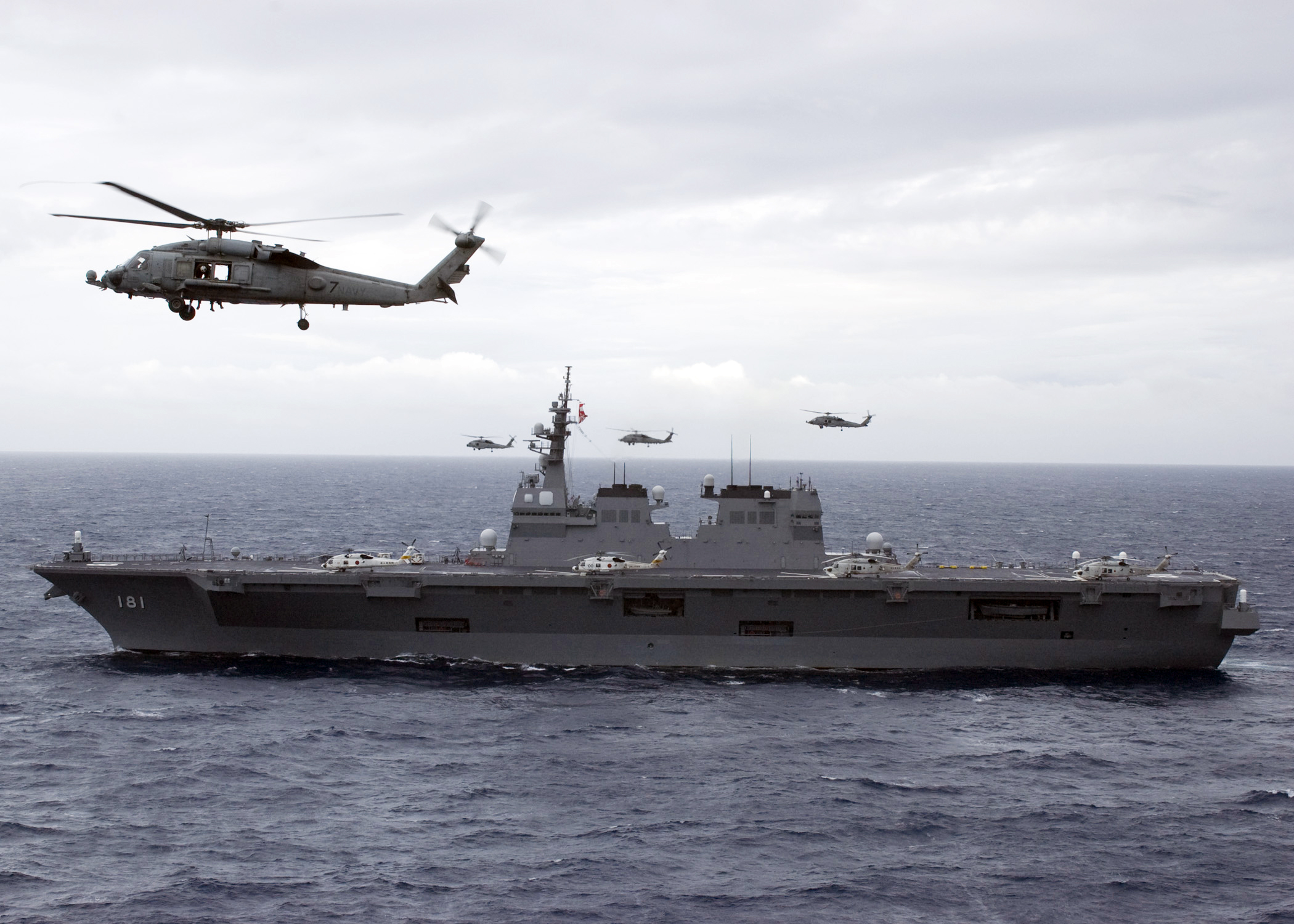 091117-N-9211M-181 PACIFIC OCEAN (Nov. 17, 2009) Ã± JS Hyuga (DDH 181) steams through the Pacific Ocean during a 26 ship formation photo exercise while Seahawk helicopters from the Chargers, Helicopter Anti-Submarine Squadron (HS) 14, fly in formation alongside.  George Washington, the NavyÃ­s only permanently forward-deployed aircraft carrier participated in a photo exercise which was the culmination of ANNUALEX 21G, the largest annual bilateral exercise with the U.S. Navy and the Japan Maritime Self Defense Force. (U.S. Navy photo by LT Reann S. Mommsen/RELEASED) (Reann S. Mommsen)
