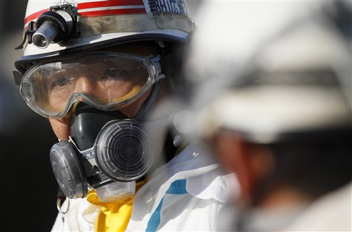 An official wears protective clothing while waiting to scan people for radiation an emergency center on Sunday, March 13, 2011, in Koriyama, northeastern Japan, two days after a giant quake and tsunami struck the country's northeastern coast.(AP Photo/Gregory Bull) (AP)