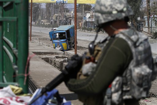 US solider stands guard near the site of explosion in Jalalabad, Afghanistan, Monday, March, 7, 2011. An Afghan Interior Ministry spokesman says a roadside bomb in the eastern city of Jalalabad has killed two policemen and wounded another 25 people.(AP Photo/Rahmat Gul) (AP)