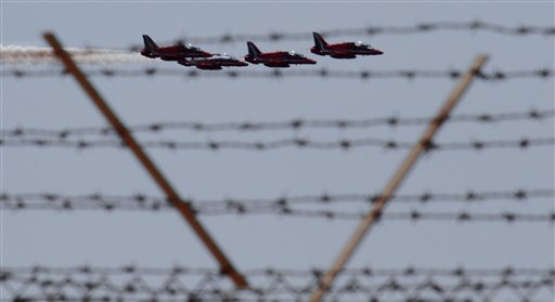 Royal red arrows aerobatic planes pass over the RAF (Royal Air Force) Akrotiri a British military base near southern port city of Limassol, Cyprus, Monday, March 21, 2011. The European Union's top foreign policy official brushed aside concerns Monday that the coalition supporting military action against Libyan leader Col. Moammar Gadhafi is already starting to fracture, saying the head of the Arab League was misquoted as criticizing the operation.Early Sunday, U.S. French and British planes began bombarding Libyan military targets with a barrage of Tomahawk cruise missiles and precision bombs. Late in the day, a cruise missile blasted Gadhafi's residential compound.(AP Photo/Petros Karadjias) (AP)