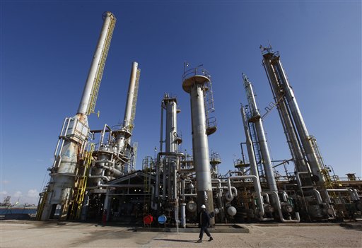 A Libyan oil worker walks in front of a refinery inside the Brega oil complex, in Brega east of Libya, on Saturday Feb. 26, 2011. Production at Brega has dropped by almost 90 percent amid the country's crisis because many employees have fled and few ships are coming to offload the product. (AP Photo/Hussein Malla) (AP)