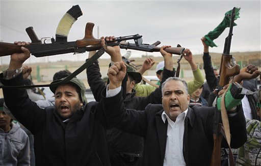 Pro-Gadhafi fighters raise their weapons as they are pictured during a government-organized visit for foreign media in Bin Jawwad, 350 miles (560 kilometers) southeast of the capital Tripoli, in Libya Saturday, March 12, 2011. The world moved a step closer to a decision on imposing a no-fly zone over Libya but Moammar Gadhafi was swiftly advancing Saturday on the poorly equipped and loosely organized rebels who have seized much of the country. (AP Photo/Ben Curtis) (AP)