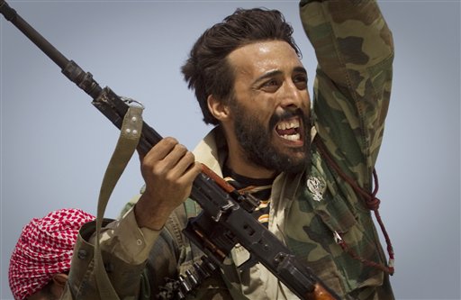 A Libyan rebel urges people to leave, as shelling from Gadhafi's forces starts landing on the frontline outside of Bin Jawaad, 150 km east of Sirte, central Libya, Tuesday, March 29, 2011.   (AP Photo/Anja Niedringhaus) (AP)