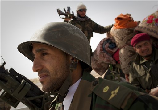 Libyan rebels stop at a checkpoint in Al-Egila, east of Ras Lanuf, eastern Libya, Sunday, March 27, 2011. The rebels claim that they have entered Ras Lanuf.  The rebels claim that they have entered Ras Lanuf. Libyan rebels took back a key oil town and pushed westward Sunday toward the capital, seizing momentum from the international airstrikes that tipped the balance away from Moammar Gadhafi's military.  Brega, a main oil export terminal in eastern Libya, fell after a skirmish late Saturday and rebel forces moved swiftly west, seizing the tiny desert town of Al-Egila  a collection of houses and a gas station on their way to the massive oil refining complex of Ras Lanouf. (AP Photo/Anja Niedringhaus) (AP)