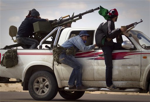 Libyan rebels retreat as mortars from Moammar Gadhafi's forces are fired on them on the frontline of the outskirts of the city of Ajdabiya, south of Benghazi, eastern Libya, Tuesday, March 22, 2011. Coalition forces bombarded Libya for a third straight night, targeting the air defenses and forces of Libyan ruler Moammar Gadhafi, stopping his advances and handing some momentum back to the rebels, who were on the verge of defeat just last week. (AP Photo/Anja Niedringhaus) (AP)