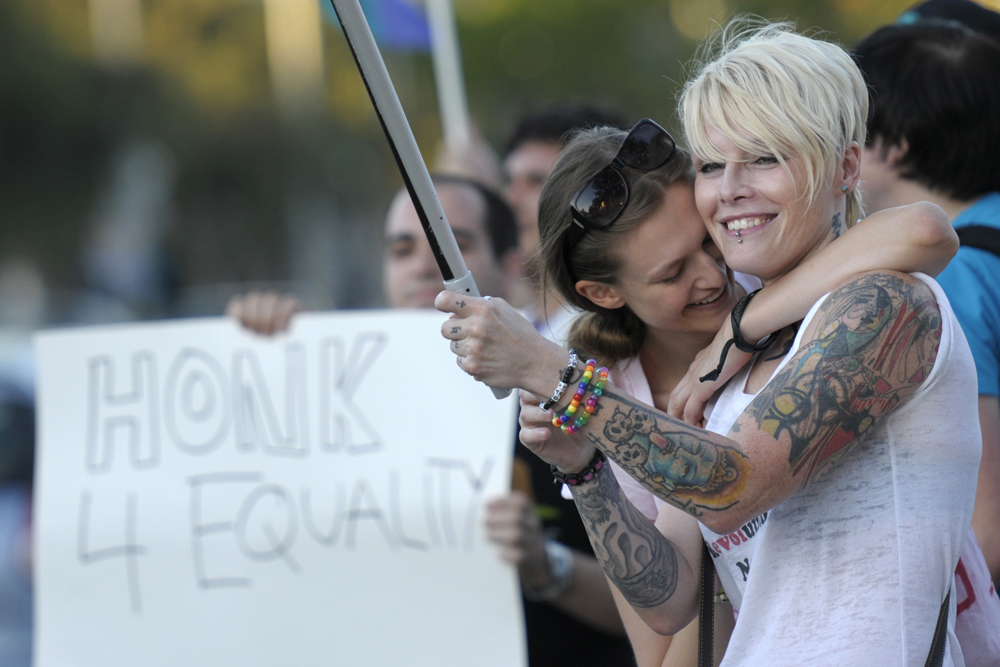 Two protestors who declined to give their names rally with other gay marriage supporters on Thursday, Aug. 19, 2010, at the intersection of Santa Monica Blvd. and San Vicente Blvd. in West Hollywood, Calif.  Protestors gathered following the U.S. Ninth Circuit Court of Appeals' freezing of a federal judge's decision ruling California's gay marriage ban, Proposition 8, unconstitutional, halting gay marriages in the state. (AP Photo/Adam Lau) (Adam Lau)