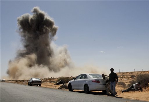 Smoke raises following an air strike by Libyan warplanes near a checkpoint near to the anti-Libyan Leader Moammar Gadhafi rebels checkpoint in the oil town of Ras Lanouf, eastern Libya, Monday, March 7, 2011.Forces loyal to Moammar Gadhafi have launched an airstrike against a rebel position in a key oil port. There were no casualties in the Monday morning attack in Ras Lanouf.Libyan rebels say they are regrouping after forces loyal to Gadhafi pounded opposition fighters with helicopter gunships, artillery and rockets on Sunday to stop the rebels' rapid advance toward the capital. (AP Photo/Hussein Malla) (AP)