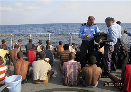 In this photo released by the Government of India Press Information Bureau, Indian naval officers distribute food to the captured pirates aboard an Indian naval ship in the Arabian Sea, off the coast of Kochi, India, Sunday, March 13, 2011. The navy captured 61 pirates from a hijacked boat after a brief gunfight in the Arabian Sea, the military said Monday, March 14, 2011. (AP Photo/ Press Information Bureau) EDITORIAL USE ONLY (AP)