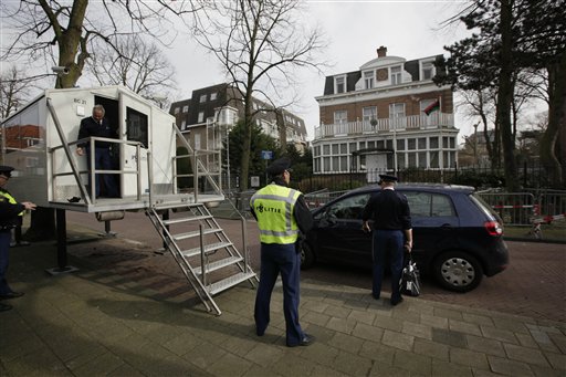Dutch police change guard duty as a pre-Gadhafi flag, chosen by forces fighting against Moammar Gadhafi, outside right window on first floor, flies outside the Libyan consulate in The Hague, Netherlands, Wednesday March 9, 2011. The International Criminal Court, based in The Hague, recently presented an overview of the alleged crimes committed in Libya since Feb. 15 2011. (AP Photo/Peter Dejong) (AP)