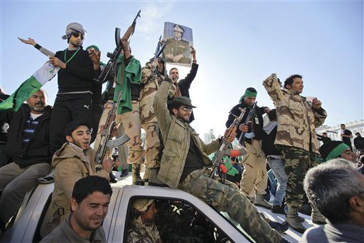 Pro-Gadhafi soldiers and supporters gather to celebrate in Green Square, Tripoli, Libya Sunday, March 6, 2011. Thousands of Moammar Gadhafi's supporters poured into the streets of Tripoli on Sunday morning, waving flags and firing their guns in the air in the Libyan leader's main stronghold, claiming overnight military successes. (AP Photo/Ben Curtis) (AP)