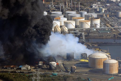 Smoke ascends over an industrial area as flames are seen in Sendai, northern Japan, Saturday, March 12, 2011. Japan launched a massive military rescue operation Saturday after a giant, quake-fed tsunami killed hundreds of people and turned the northeastern coast into a swampy wasteland, while authorities braced for a possible meltdown at a nuclear reactor. (AP Photo/Itsuo Inouye) (AP)