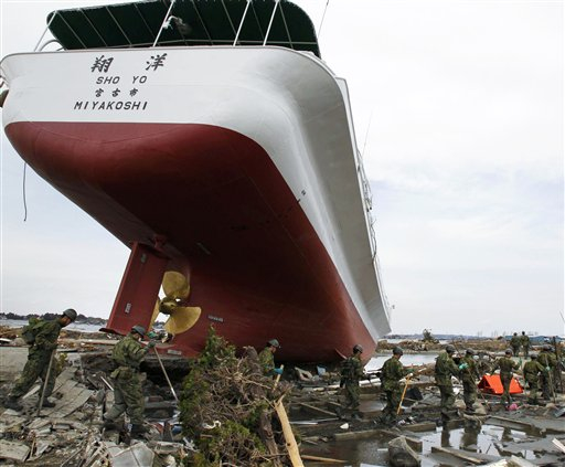 Japan Self-Defense Forces personnel search for victims around a ship swept out by Friday's tsunami in Higashimatsushima, Miyagi Prefecture, northern Japan, Monday, March 14, 2011, three days after a massive earthquake and the ensuing tsunami hit Japan's east coast. (AP Photo/Kyodo News) JAPAN OUT, MANDATORY CREDIT, NO SALES IN CHINA, HONG  KONG, JAPAN, SOUTH KOREA AND FRANCE (AP)