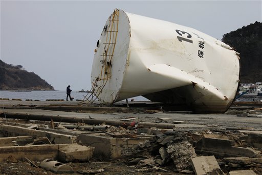 In this photo taken Friday, March 25, 2011, a man walks at the devastated city of Onagawa, Miyagi prefecture, northeastern Japan. As March 11 massive tsunami ravaged this Japanese fishing town, hundreds of residents fled for the safest place they knew: the local nuclear power plant. More than two weeks later, 240 remain, watching TV or playing ball games with their children next to three atomic reactors. It's a startling contrast to the troubled nuclear plant 75 miles (120 kilometers) southeast, where radiation leaks have forced an evacuation of nearby towns, terrifying the nation. (AP Photo/Vincent Yu) (AP)