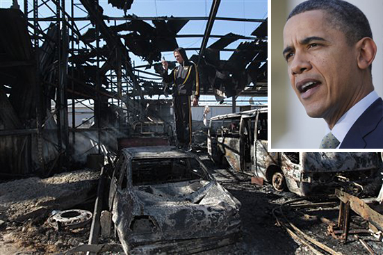 In this image taken during an organized trip by the Libyan authorities, A Libyan soldier in civilian clothes takes a picture amidst the wreckage of what was described as a maintenance warehouse  hit by two missiles Monday evening on a Naval base in Tripoli, Libya, Tuesday March 22, 2011. Missile transporters and launchers were among the destroyed hardware. A senior defense official, speaking on condition of anonymity to discuss classified data, said Monday that the attacks thus far had reduced Libya's air defense capabilities by more than 50 percent  (AP Photo/Jerome Delay) (Jerome Delay)