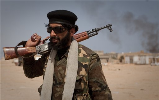 A Libyan rebel walks on the front line outside of Bin Jawaad, 150 km east of Sirte, central Libya, Tuesday, March 29, 2011. Rockets and tank fire sent Libya's rebel volunteers in a panicked scramble away from the front lines Tuesday, suggesting that the opposition is still no match for the superior firepower and organization of Gadhafi's forces, despite an international campaign of deadly airstrikes.  (AP Photo/Anja Niedringhaus) (AP)