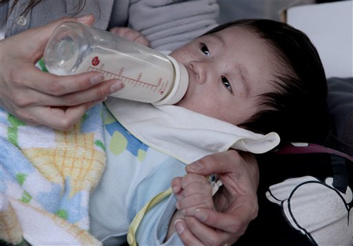 A mother feeds her baby at an evacuation center in Yamagata Prefecture, northern Japan, Thursday, March 24, 2011. Hundreds of thousands remain homeless, squeezed into temporary shelters without heat, warm food or medicine and no idea what to call home after the March 11 tsunami swallowed up communities along the coast and dozens of strong aftershocks continued to shake the nation. (AP Photo/Mark Baker) (AP)
