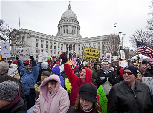 Protesters march outside the state Capitol Saturday, March 12, 2011, in Madison, Wis. While Gov. Scott Walker has already signed a contentious collective bargaining bill into law, demonstrators insist the fight is not over.  For some, the focus has shifted from trying to stop passage of the bill to generating momentum for recall efforts against Republicans. Others are simply venting their frustration over the law taking away most of public workers' collective bargaining rights. (AP Photo/Morry Gash) (AP)