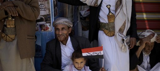 A Yemeni girl holding her national flag sits with her father along with anti-government protestors during a demonstration demanding the resignation of Yemeni President Ali Abdullah Saleh, in Sanaa,Yemen, Wednesday, March 23, 2011. Yemen's parliament enacted sweeping emergency laws Wednesday after the country's embattled president asked for new powers of arrest, detention and censorship to quash a popular uprising demanding his ouster. Arabic reads on the flag, " Leave". (AP Photo/Muhammed Muheisen) (AP)