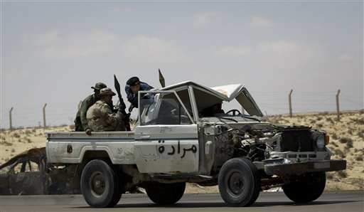 Rebel fighters retreat out of Ajdabiya during an advance by pro-Gadhafi forces, on the outskirts of Ajdabiya, Libya Saturday, April 9, 2011. Government soldiers and rebel gunmen battled in the streets of the key front-line city of Ajdabiya Saturday after the Libyan military used shelling and guerrilla-style tactics to open its most serious push into opposition territory since international airstrikes began. (AP Photo/Ben Curtis) (AP)