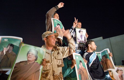 Holding posters of their leader, supporters of Moammar Gadhafi chant slogans following a NATO airstrike in Tripoli, Libya, early Saturday, April 23, 2011. (AP Photo/Darko Bandic) (AP)