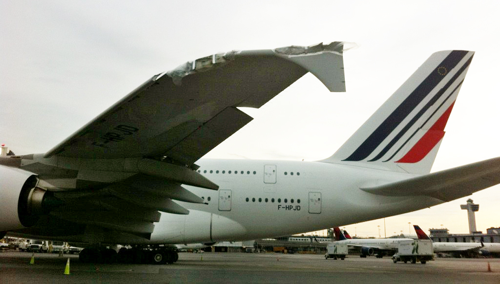 A damaged Airbus A380 belonging to Air France sits on the runway at John F. Kennedy International Airport, Tuesday, April 12, 2011 in New York. The worldâs largest passenger aircraft clipped a much smaller Bombardier CRJ700 on a wet tarmac at JFK on Monday, April 11. No one was injured. (AP Photo/NYCAviation) (AP)