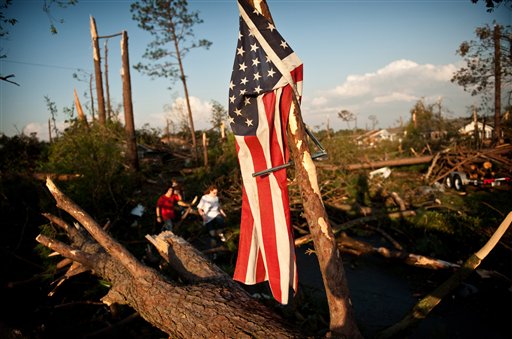 Will Harrison's flag hangs from a fallen tree after it was blown off his house when a tornado ripped through the Cottonade neighborhood Saturday, April 16, 2011 in Fayetteville, N.C. Homes and businesses were badly damaged Saturday by a severe storm system that whipped across North Carolina, bringing flash floods, hail and reports of tornadoes from the western hills to the streets of Raleigh. (AP Photo/The Fayetteville Observer, Andrew Craft) MANDATORY CREDIT; MAGS OUT; NO SALES (AP)