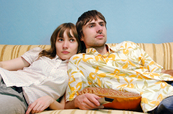 Young couple watching TV together on the couch