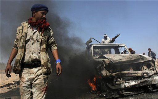 Libyan rebels inspect two destroyed military vehicles of pro-Gadhafi forces that rebels claim were targeted by a NATO strike along the front line near Brega, Libya Tuesday, April 5, 2011. Libya's rebel forces are looking more effective on the front and even scrapping back some of the territory lost to Moammar Gadhafi's army, but the rag tag fighters are still a long way from being able to march to Tripoli.  (AP Photo/Nasser Nasser) (AP)