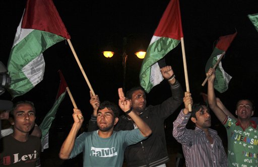 Palestinians wave flags and chant slogans in support of a reconciliation between the rival Fatah and Hamas movements, in Gaza City, Wednesday, April 27, 2011. Palestinians have reached initial agreement on reuniting their rival governments in the West Bank and Gaza, officials from both sides said Wednesday, a step that would remove a main obstacle in the way of peace efforts with Israel. (AP Photo/Adel Hana) (AP)