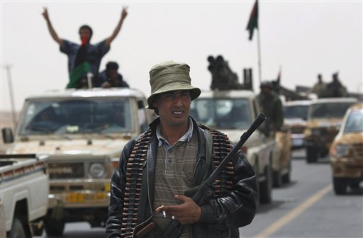 A Libyan rebel fighter guards while a convoy of retreating armed Libyan rebels vehicles pass through the western gate of Ajdabiya, Libya Friday, April 15, 2011. From her father's compound, struck by U.S. bombs exactly 25 years ago, Moammar Gadhafi's daughter sent a defiant message early Friday: Libya was not defeated by airstrikes then and won't be defeated now, she told a cheering crowd. (AP Photo/Nasser Nasser) (AP)