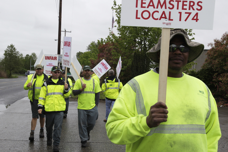 Workers form a picket line at a Waste Management Inc. facility in Seattle, Wednesday, April 21, 2010. Seattle-area garbage workers represented by Teamsters union Local 174 went on strike Wednesday morning. (AP Photo/Ted S. Warren) (Ted S. Warren)