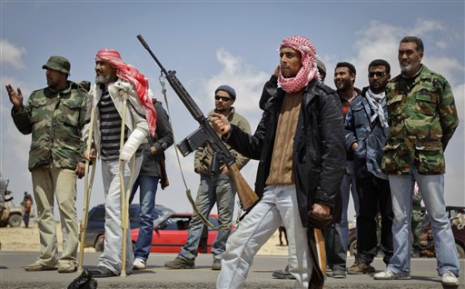 Rebel fighters, one on crutches, are seen near the front line east of Brega, Libya, Sunday, April 3, 2011. The Libyan rebel movement that controls the country's eastern half wants to install a parliamentary democracy across the country once they topple the regime of longtime ruler Moammar Gadhafi, according to Abdel-Hafidh Ghoga, vice chairman of the National Provisional Council. (AP Photo/Ben Curtis) (AP)