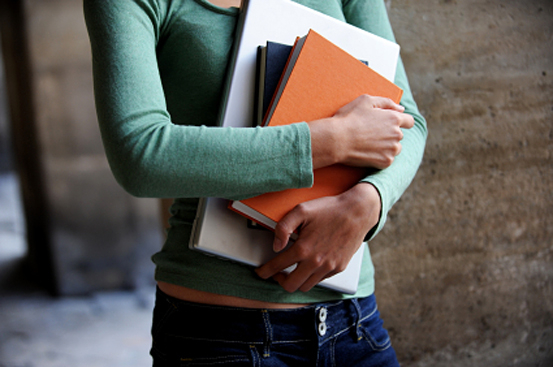 Close up of a female university student holding books and a laptop
[url=http://www.istockphoto.com/file_search.php?action=file&lightboxID=4140694][img]http://www.erichood.net/edubanner.jpg[/img][/url] (Eric Hood)