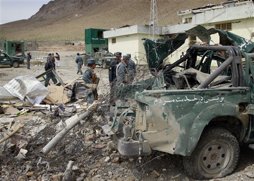 Afghan police men and officials stand close to a damaged police vehicle at the scene of a suicide car bomb explosion on the out skirts of Kabul, Afghanistan on Thursday, April 14, 2011. A suicide car bomber detonated a truck of explosives covered in wood at a government compound in Musayi district, about 40 miles south of the Afghan capital, according Daud Amin, deputy police chief in Kabul. Six members of the Afghan national security forces were injured, he said. (AP Photo/Musadeq Sadeq) (AP)
