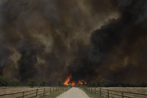 Smoke rises from an uncontrolled wildfire burning near Possum Kingdom, Texas, Tuesday, April 19, 2011.  (AP Photo/LM Otero) (AP)