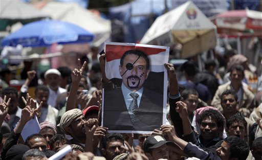 Anti-government protestors hold up a defaced poster of Yemeni President Ali Abdullah Saleh during a demonstration demanding his resignation in Sanaa, Yemen, Wednesday, April 20, 2011. A Yemeni opposition activist said a gunmen on A motorcycle opened fire at hundreds of demonstrators camped out overnight in a western port city, killing at least one and wounding several protesters. (AP Photo/Muhammed Muheisen) (AP)