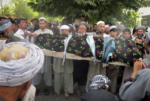 Afghani people hold the lifeless body of one of the four Afghans, killed during a NATO raid in Taloqan, Takhar province, north of Kabul, Afghanistan on Wednesday, May 18, 2011.  More than 1,000 protesters poured into a northern Afghan city Wednesday, shouting "Death to America!" and calling for justice as they clashed with security forces following an overnight NATO raid they claim killed four civilians. (AP Photo/Fulad Hamdard) (AP)