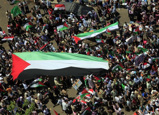 Egyptians carry a giant Palestinian flag during a protest against Israel's closure of Gaza as they march at Tahrir Square, the focal point of Egyptian uprising, in Cairo, Egypt Friday, May 13, 2011. (AP Photo/Amr Nabil) (AP)