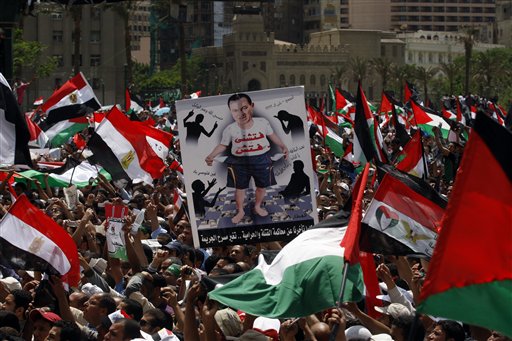 An Egyptian man holds a caricature picture of deposed President Hosni Mubarak with Arabic word reading, "search me," during a rally in Tahrir square in Cairo, Egypt Friday May 13, 2011. Egyptian authorities have ordered the detention of Suzanne Mubarak, wife of deposed President Hosni Mubarak, the government-run MENA news service said Friday. (AP Photo/Khalil Hamra) (AP)