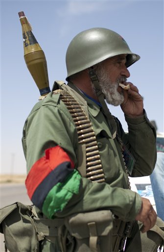A rebel fighter eats bread in a checkpoint in Ajdabiya, Libya, Monday, May 9, 2011.  (AP Photo/Rodrigo Abd) (AP)