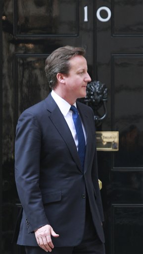 Britain's Prime Minister David Cameron, exits his official residence at 10 Downing Street in London, prior to a meeting, Monday, April 18, 2011. Cameron won't be wearing a formal morning suit with long tails to the royal wedding. Officials said Monday April 18, 2011, that the prime minister will wear a business suit to the April 29 wedding of Prince William and Kate Middleton. The invitation gives men a choice between suits, military uniforms, or traditional formal wear, which includes a long coat with tails. Religious leaders are allowed to wear their clerical outfits.(AP Photo/Lefteris Pitarakis) (AP)