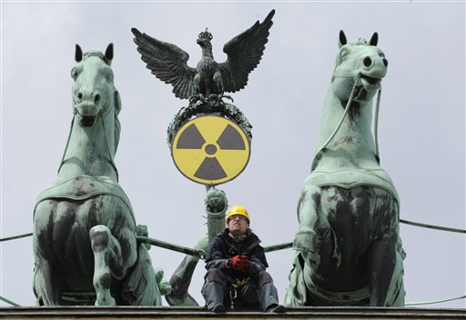 An environmental activist sits on top of the Brandenburg Gate after Greenpeace activists fixed a radioactive sign to the Quadriga in Berlin, Sunday May 29, 2011 to protest against the nuclear power policy of German Government. (AP Photo/dapd/Michael Gottschalk) (AP)