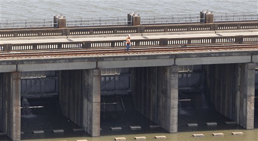 Workers stand atop the Morganza Spillway in Morganza, La., Thursday, May 12, 2011, as water seeps through, bottom, during an aerial tour of areas that may be affected by flooding if the spillway is opened. (AP Photo/Patrick Semansky) (AP)