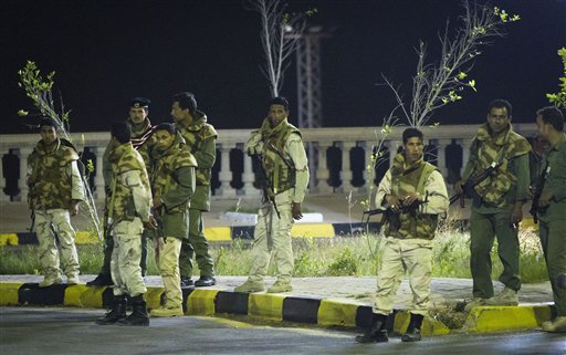 In this photo made on a government organized tour, Libyan soldiers stand near damaged government building following an airstrike in Tripoli, Libya, early Saturday, April 30, 2011.(AP Photo/Darko Bandic) (AP)