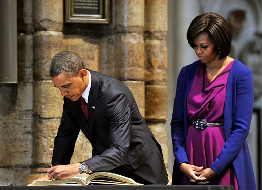 US President Barack Obama,  watched by his wife, first lady Michelle Obama, signs the distinguished visitors book during a tour of Westminster Abbey, in central London, Tuesday May 24, 2011. President Barack Obama and first lady Michelle Obama traded-in Irish charm for the pomp and pageantry of Buckingham Palace Tuesday as they opened a state visit to Britain at the invitation of Queen Elizabeth II. (AP Photo/John Stillwell/Pool) (AP)